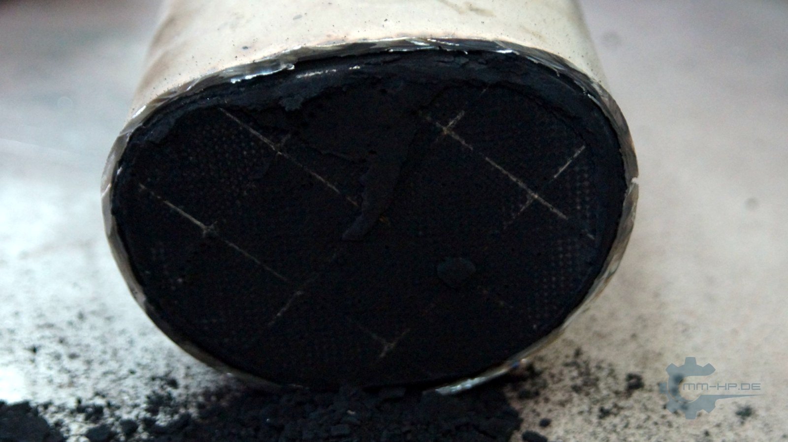 Stirnseite eines ausgebauten Partikelfilters aus Siliziumkarbid, mit Ruß belegt, die Klebefugen zwischen den quadratischen Segmenten sind als Linien zu erkennen