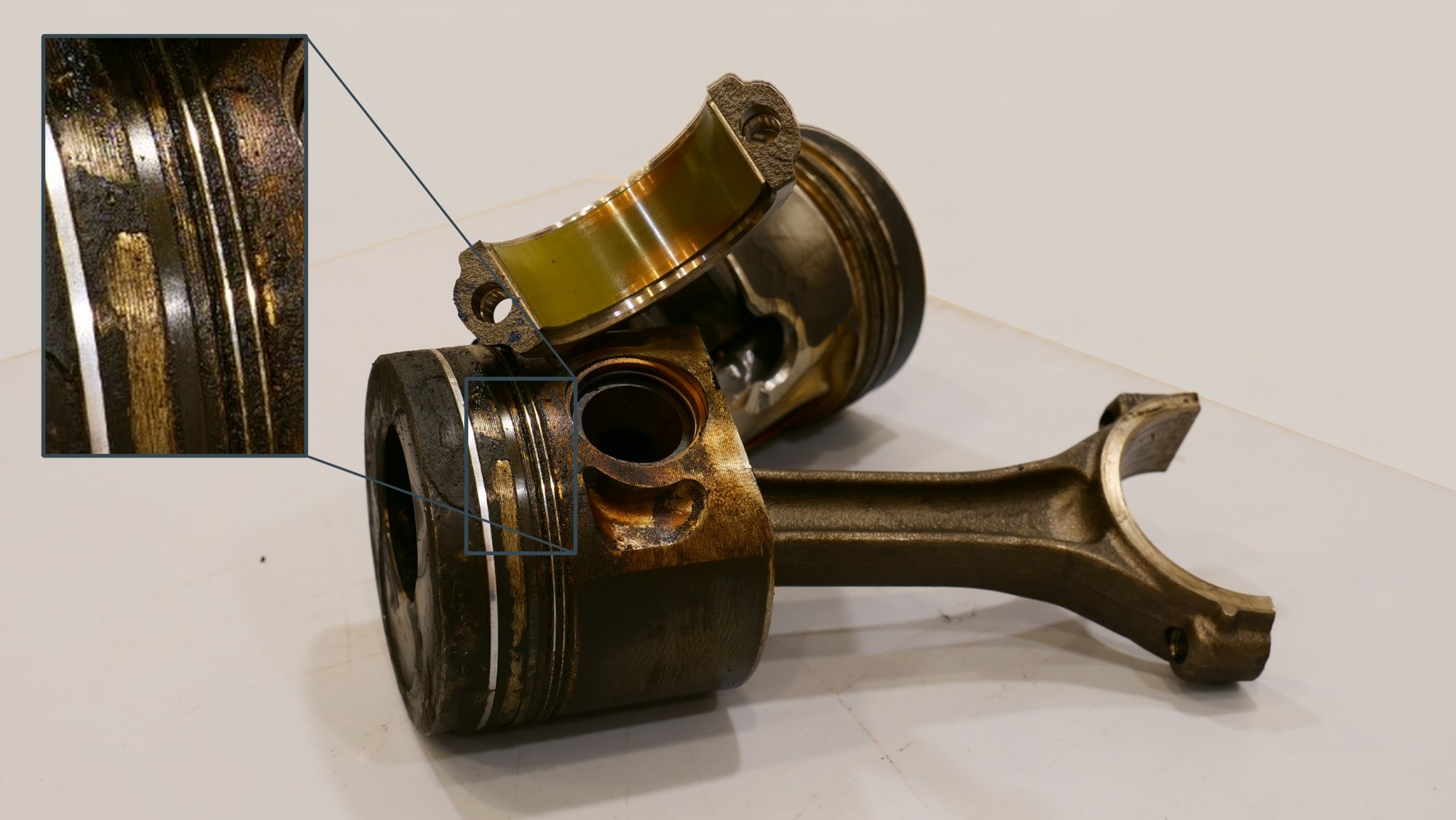Dismantled piston with coked ring grooves, the piston rings stuck firmly in the carbon deposits
