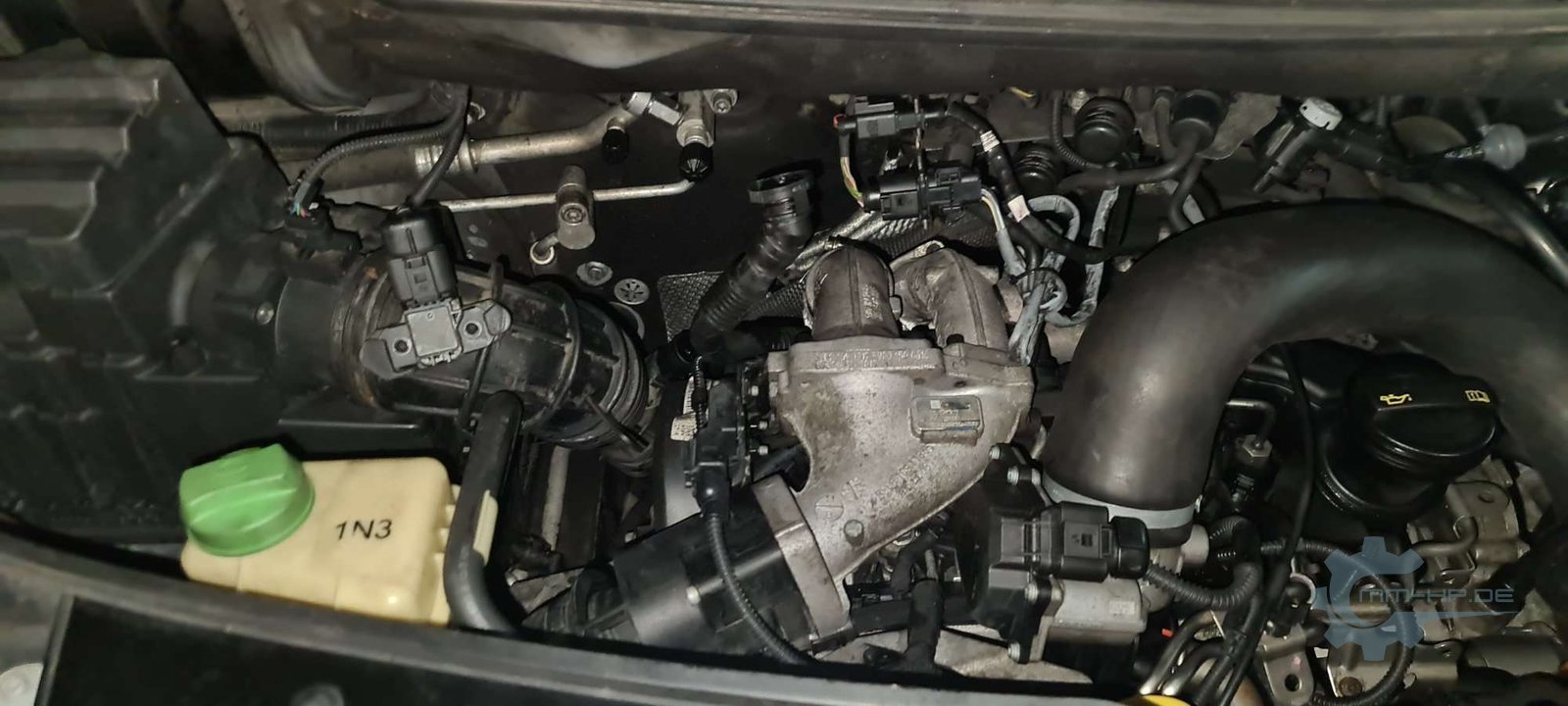 Engine bay of a VW T5 with charge-air pipe, expansion tank and wiring