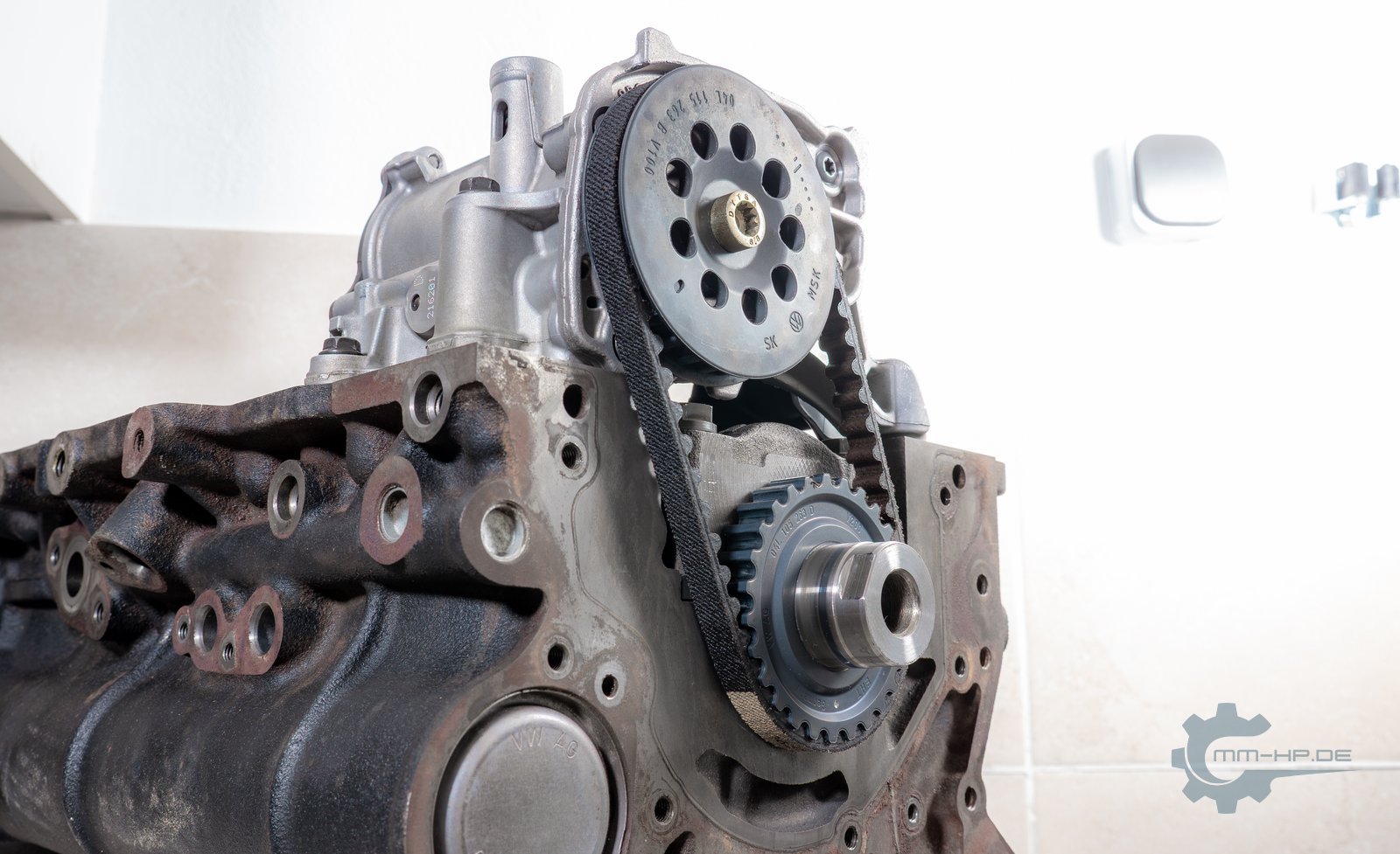 Engine block with oil pump driven by a black toothed belt